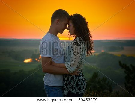 romantic couple at sunset on bright yellow sky background, love tenderness concept, young adult people