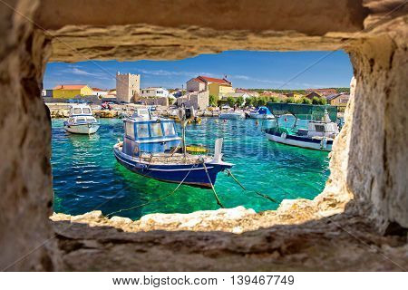 Razanac turquoise waterfront through stone window Dalmatia Croatia