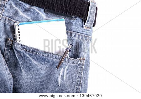 A notebook in some jeans trousers. Digital photo.