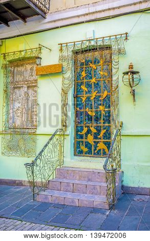 The house entrance and the window decorated with the curtains and tulle made of the metal wire Tbilisi Georgia.