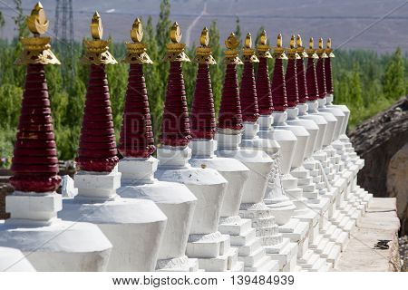Buddhist chortens white stupa and Himalayas mountains in the background near Shey Palace in Ladakh India