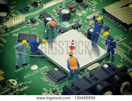 group of mini mechanic work on mainboard and CPU they try to open chip for repair - can use to display or montage on product