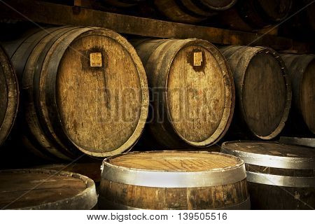 Wine barrels stacked in the old cellar of the winery.