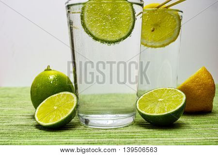 Glass with cold sparkling mineral water lime and lemon seltzer