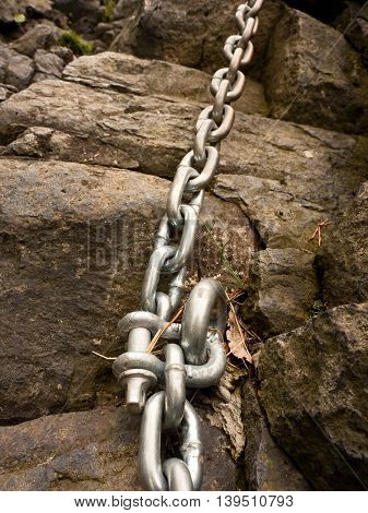 Steel Bolt Anchor Eye In Hard Basalt Rock. End Of Steel Chain