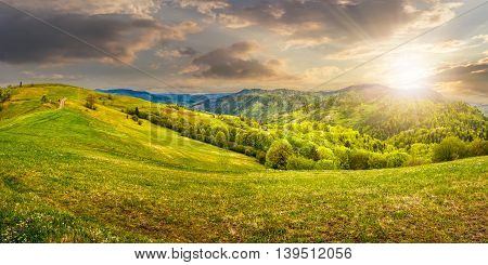 Idyllic view of pretty farmland rolling hills. Rural landscape near the forest in mountains in evening light