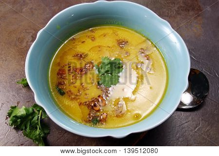 Yellow Lentil soup or Arhar Daal fry with the tadka of cumin seeds garlic and green chilies on a moody background