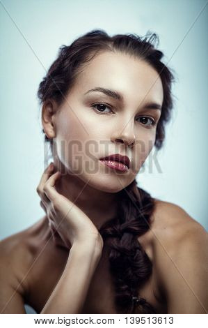 Fashion portrait of gorgeous young brunetee woman.Chaos hair style with braid. Shallow depth of field