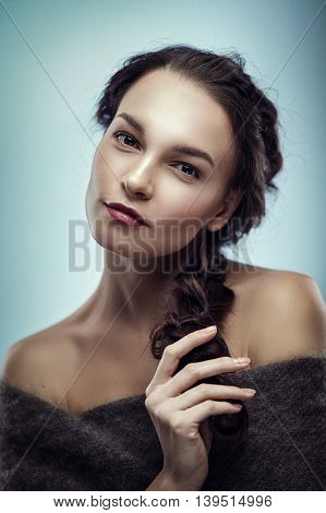 Fashion portrait of gorgeous young brunetee woman.Chaos hair style with braid. Shallow depth of field