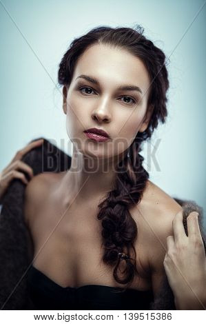 Fashion portrait of gorgeous young brunetee woman.Chaos hair style with braid. Shallow depth of field