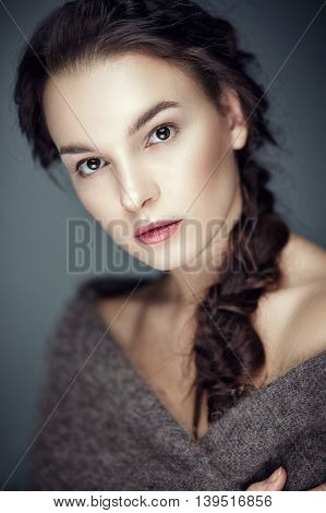 Fashion portrait of gorgeous young brunetee woman.Chaos hair style with braid. Shallow depth of field