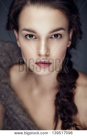 Fashion portrait of gorgeous young brunetee woman.Chaos hair style with braid. Shallow depth of field