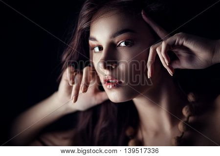 Fashion portrait of gorgeous young brunetee woman. Shallow depth of field. Low key portrait on black