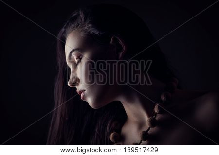 Fashion portrait of gorgeous young brunetee woman. Shallow depth of field. Low key portrait on black