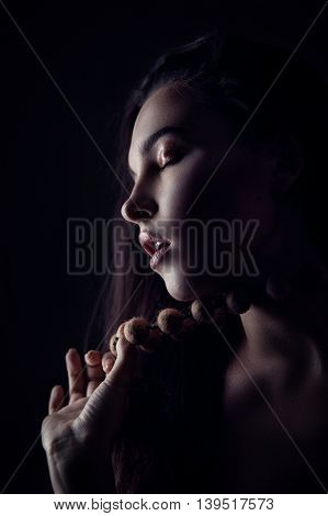 Fashion portrait of gorgeous young brunetee woman. Shallow depth of field. Low key portrait on black