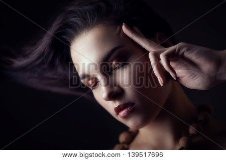 Fashion portrait of gorgeous young brunetee woman. Shallow depth of field. Low key portrait on black