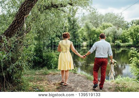 Lovers Hold Hands And Walk In The Park