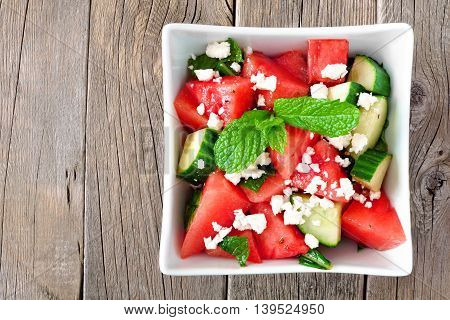 Summer Salad With Watermelon, Cucumber And Feta Cheese In A Square Bowl, Above View On Wood Backgrou