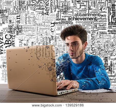 Boy writes and looks at his laptop