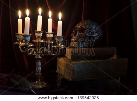 Mystic still life with candelabrum, skull and old book in the darkness
