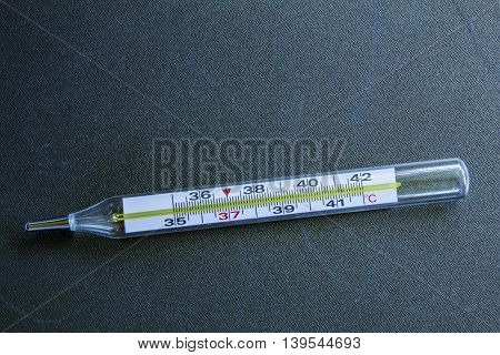 Medical Glass Mercury Thermometer On A Black Steel Background