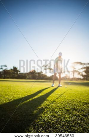 Full length of man playing golf on field against clear sy