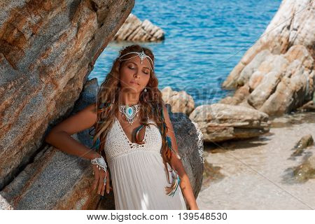 Beautiful young bride in white wedding dress on beach