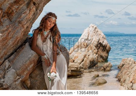 Beautiful young bride in white wedding dress on beach