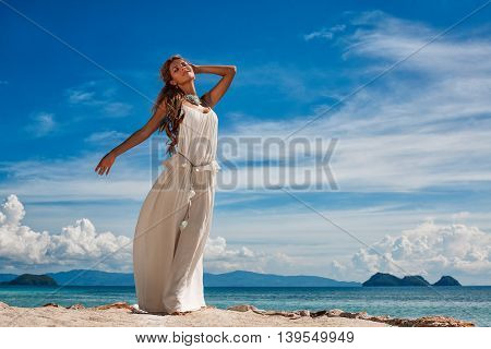 beautiful young woman in white dress on the beach