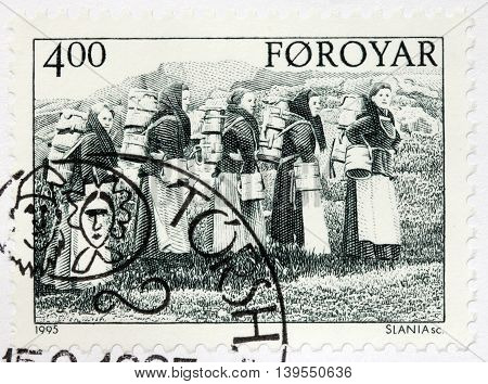 LUGA RUSSIA - JUNE 25 2016: A stamp printed by FAROE ISLANDS shows dairymaids carrying buckets circa 1995.