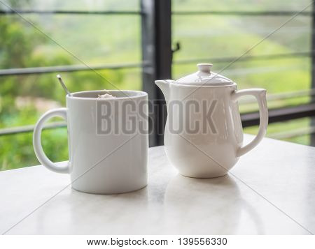 White Teapot And Tea Cup On The Table At Boh Tea Plantation