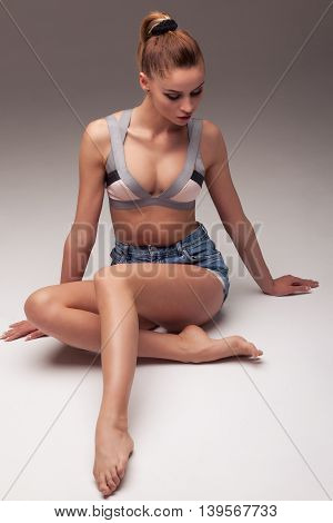 sexy woman in shorts and lingerie on a gray gradient background aroused body