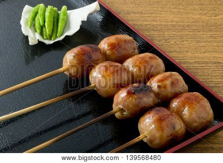 Food and Cuisine A Plate of Thai Grilled Sausages on Wooden Skewer Served with Pickled Ginger Cabbage and Chili Pepper.