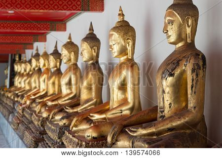 Gold Buddha Statue In Public Temple In Thailand. Row Of Buddha Imanges In Different Posture.
