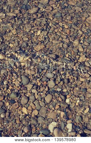 River bank with rocks at the bottom with a small wave runup