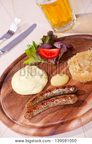 two bratwurst sausages on a wooden plate