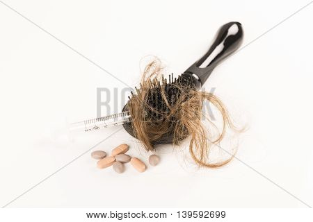 Close-up of hair loss, long hair, alopecia treatment on white background with brush