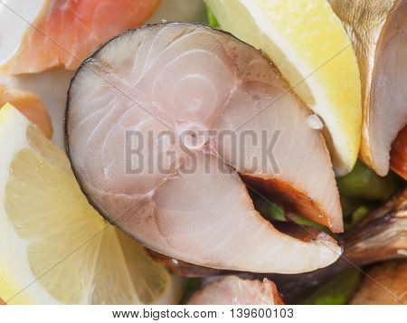Close-up of a cold-smoked mackerel with lemon on a dish