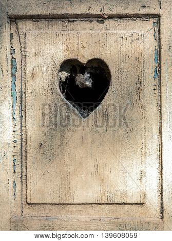 old wooden door in meran Tirol Italy with a carved romantic heart