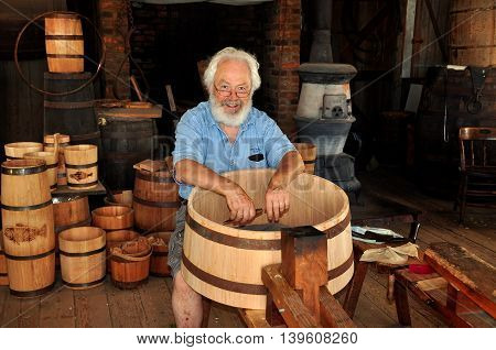 Mystic Connecticut- July 11 2015: Cooper at work making a wooden barrel in the Cooperage Shop at Mystic Seaport