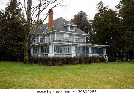 WEQUENTONSING, MICHIGAN / UNITED STATES - DECEMBER 23, 2015: The front porch of a home, christened Brookside, on Beach Drive in Wequetonsing, is protected with plastic sheeting from the winter weather.