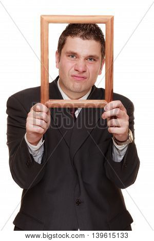 Nerdy funny business man guy framing his face with wooden empty picture frame isolated on white background