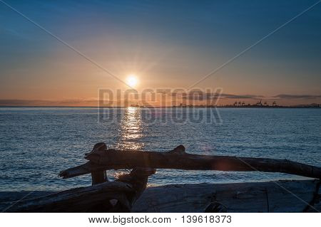 sunset over driftwood at twilight in Point Roberts Washington state USA