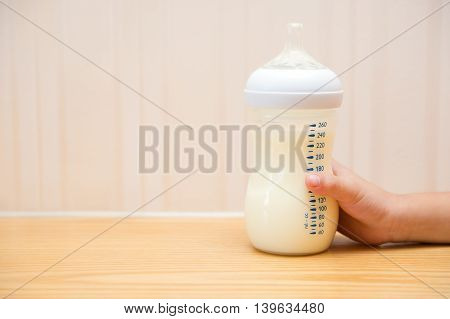 kid getting a baby bottle of powdered milk without lid at home