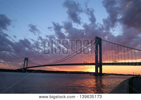 NEW YORK - JULY 23, 2016: Verrazano Bridge at sunset in New York .The Verrazano Bridge is a double-decked suspension bridge that connects the boroughs of Staten Island and Brooklyn
