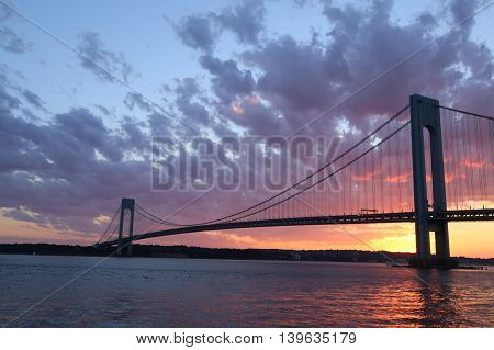 NEW YORK - JULY 23, 2016: Verrazano Bridge at sunset in New York .The Verrazano Bridge is a double-decked suspension bridge that connects the boroughs of Staten Island and Brooklyn