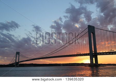 NEW YORK - JULY 23, 2016: Verrazano Bridge at sunset in New York .The Verrazano Bridge is a double-decked suspension bridge that connects the boroughs of Staten Island and Brooklyn