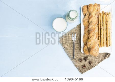 Breadsticks and milk on sky blue table background.Snack with meal or food of relax and holiday.Top view.