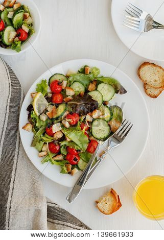 Fresh vegetable salad on a white table. Top view.