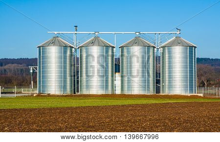 silver silo in rural landscape under blue sky